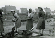 Steine machen war Frauenarbeit. Ziegelsteine waren 1948/49 auf dem Markt schwer zu bekommen. Steine wurden daher in Eigenarbeit hergestellt. Die Frauen mischten Hochofenschlacke, Sand und Zement mit Wasser an und stampften die Masse in eine Eisenform. Helene K. ist links im Bild zu sehen.