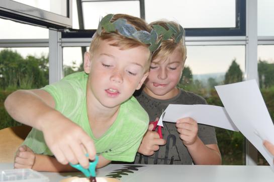 Zwei Jungen basteln einen Lorbeerkranz. (vergrößerte Bildansicht wird geöffnet)