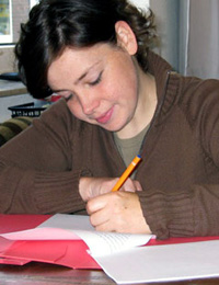 Schülerin am Schreibtisch beim Schreiben ihrer Facharbeit