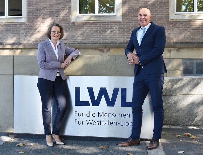 Ina Scharrenbach und Dr. Georg Lunemann vor einem LWL-Schild