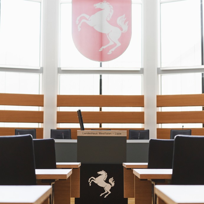 Leerer Plenarsaal mit Rednerpult und Wappen von Westfalen-Lippe. (vergrößerte Bildansicht wird geöffnet)