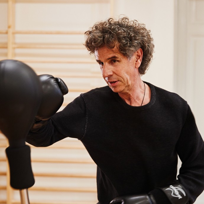 Ein Mann schlägt mit einem Boxhandschuh auf einen Punchingball. (vergrößerte Bildansicht wird geöffnet)